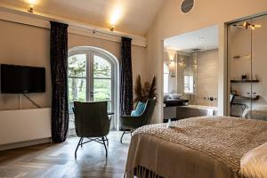 a bedroom with a large bed and a bathroom at 't Ganzenest Restaurant # klein hotel in Rijswijk