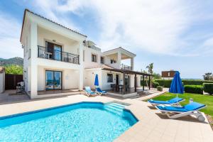 a villa with a swimming pool and a house at Seafront Villa Ocean Pearl - Private Beach Area & Pool in Polis Chrysochous
