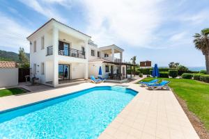 a villa with a swimming pool in front of a house at Seafront Villa Ocean Pearl - Private Beach Area & Pool in Polis Chrysochous +38 photos