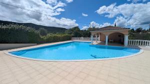 a swimming pool in a yard with a house at Gîte Barbera "Les Oliviers" in Grospierres