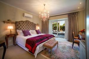 sypialnia z dużym łóżkiem i żyrandolem w obiekcie Baruch Guesthouse on Lovell w mieście Stellenbosch
