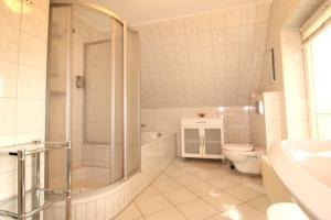 a bathroom with a shower and a toilet and a sink at Ferienhaus Lütt Matten in Wustrow +19 photos