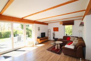 a living room with a couch and a tv at Ferienhaus Lütt Matten in Wustrow