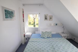 a white room with a bed and a window at Ferienhaus Lütt Matten in Wustrow