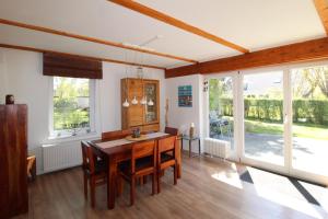 a dining room with a table and chairs and windows at Ferienhaus Lütt Matten in Wustrow