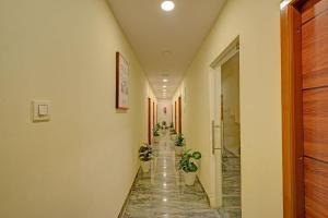a corridor with potted plants in a hallway at FabHotel Casa Grand Ecil in Hyderabad