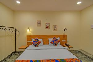 a bedroom with a large bed with colorful pillows at FabHotel Casa Grand Ecil in Hyderabad