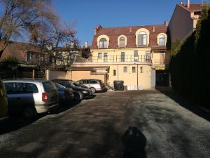 a parking lot with cars parked in front of a building at Mátyás Szállás Panzió in Szombathely