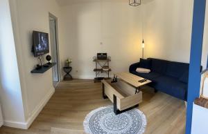 a living room with a blue couch and a table at Escale Pesmoise in Pesmes