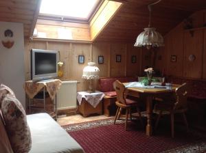 sala de estar con sofá, mesa y TV en Apartements Ingrid Unhoch-Raggl, en Oberammergau
