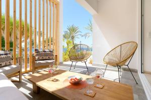 a living room with a table and two chairs at Deva Beach Boutique Apartments in San Bartolomé