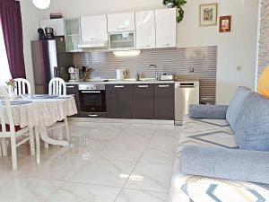 a kitchen with a couch and a table in a room at Apartment Iryna in Rogoznica