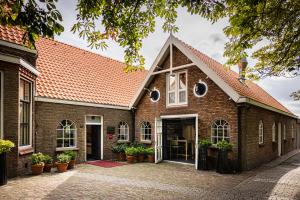 a brick building with windows and plants at 't Ganzenest Restaurant # klein hotel in Rijswijk