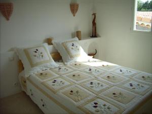 a bedroom with a bed with white sheets and pillows at Gîte Barbera "Les Oliviers" in Grospierres +11 photos