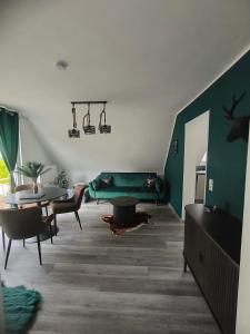a living room with a green couch and a table at Ferienwohnung Kampić Hirsch & Heimat in Rottweil
