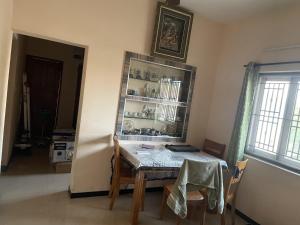a dining room with a table and a shelf at Tova in Mettuppālaiyam +4 photos