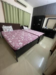 a bedroom with a bed with a pink comforter at Tova in Mettuppālaiyam