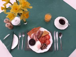 a table with a plate of breakfast food and a cup of coffee at Forest How Guest House in Eskdale
