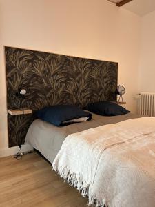 a bedroom with a large bed with a large headboard at Escale Pesmoise in Pesmes