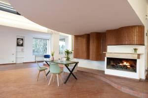a living room with a fireplace and a table and chairs at Firmamento Royal House in Rocca Priora