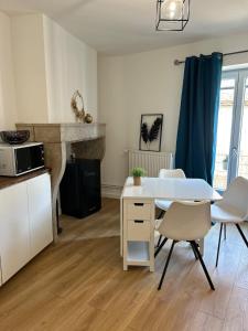 a kitchen with a white table and chairs in a room at Escale Pesmoise in Pesmes