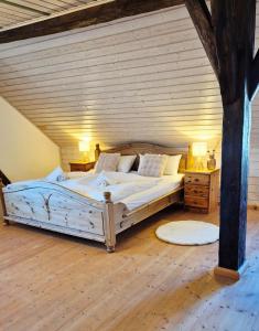 a large bed in a room with a wooden ceiling at Das Max & Fritz in Wegscheid