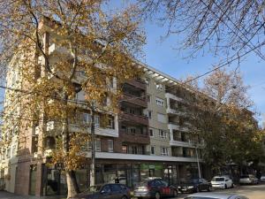 an apartment building with cars parked in front of it at StarLux Residence - Because you deserve it! in Ćuprija