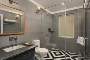 a bathroom with a toilet and a glass shower at Trulyy The Jawai Leopard Kingdom in Jāmb