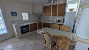 a kitchen with a table and some chairs in it at Gîte Barbera "Les Oliviers" in Grospierres