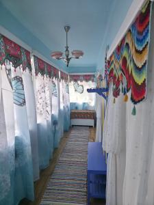 a hallway with curtains and a bed in a room at La Umbra Muntilor Traditional House in Ocoliş +21 photos
