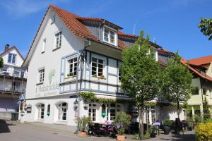 a white building with a red roof at Hotel Rebstöckle in Hagnau