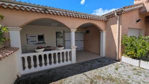 a house with an arched entryway with a balcony at Gîte Barbera "Les Oliviers" in Grospierres
