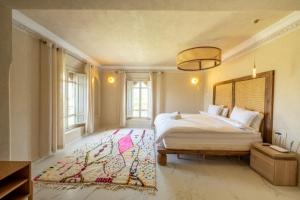 a bedroom with a large bed and a rug at Villa Aurea Marrakech in Gzoula +40 photos