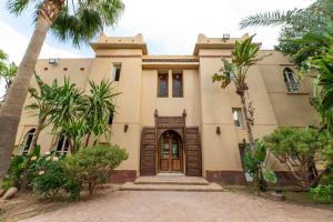a house with palm trees in front of it at Villa Aurea Marrakech in Gzoula
