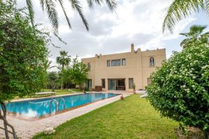 an exterior view of a house with a swimming pool at Villa Aurea Marrakech in Gzoula
