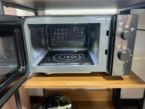 a microwave oven sitting on top of a table at Hokkaido Wander House in Ashibetsu