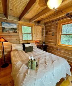 a bedroom with a large bed in a room with wooden walls at Cedar Gap Hideaway in Indiana in Birdseye