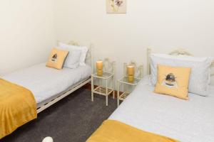two twin beds in a room with two candles at Shell Cottage in Whithorn +3 photos