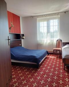a bedroom with a bed and a chair in it at Hotel Restauracja Venus in Moderówka +49 photos