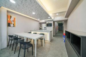 a dining room with a white table and chairs at 湯韻溫泉 in Jiaoxi