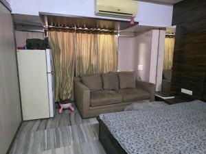 a living room with a couch and a bed at Tova in Mettuppālaiyam