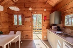 a kitchen in a wooden cabin with a table and chairs at Nice Camps - Lloret de Mar in Lloret de Mar