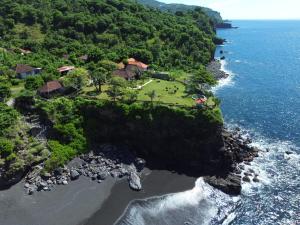 an aerial view of a house on a island in the ocean at Makawi Tuwa Cliff - Luxury Cliff Stay with Private Beach, Infinity Pools and Ocean View in Seraya