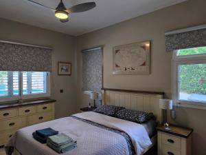 a bedroom with a bed and two windows at Villa Best Holiday Sea View Private Pool near Coral Bay with Garden and BBQ in Peyia +108 photos