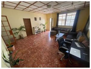 a living room with a couch and a desk in a room at Comfy room in Wilkinson road ft in Freetown