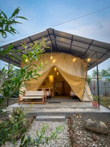 a tent with a bed and a couch in it at Hotel Tharu Garden in Sauraha