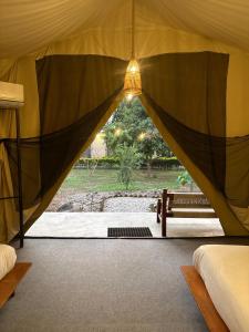 a tent with a bench and a light in it at Hotel Tharu Garden in Sauraha