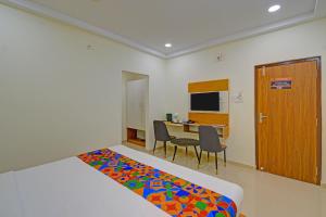 a room with a bed and a desk with a computer at FabHotel GG Stays in Lingampalli