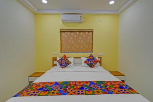 a bedroom with a bed with a colorful quilt on it at FabHotel GG Stays in Lingampalli +30 photos