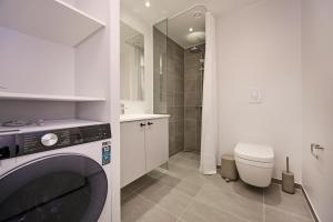 a bathroom with a washing machine and a toilet at World Trade Center Ballerup - Forenom in Ballerup